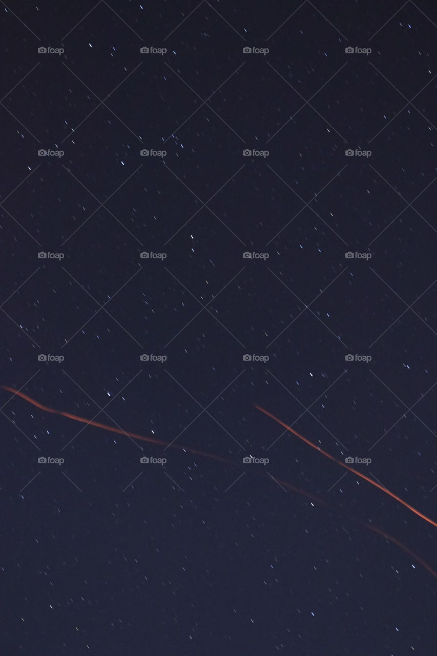 The starry night sky with passing sparks from a campfire