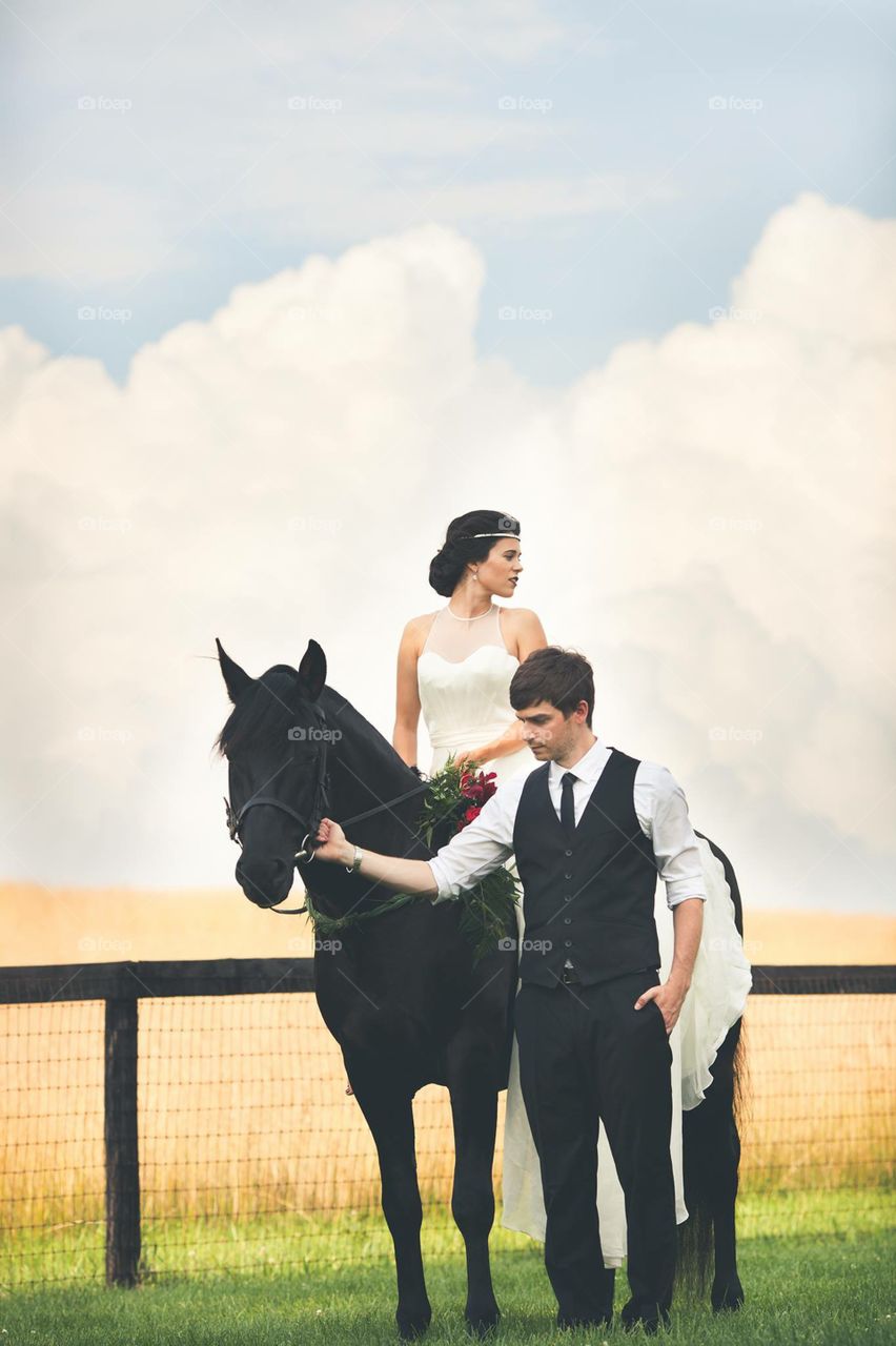 Couple With Horse. Bride and groom with black horse