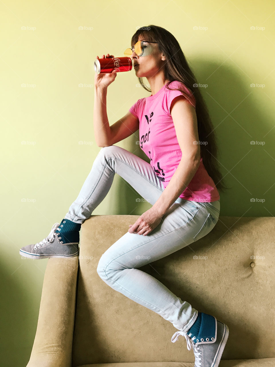 Young woman with long hair drinking coca cola