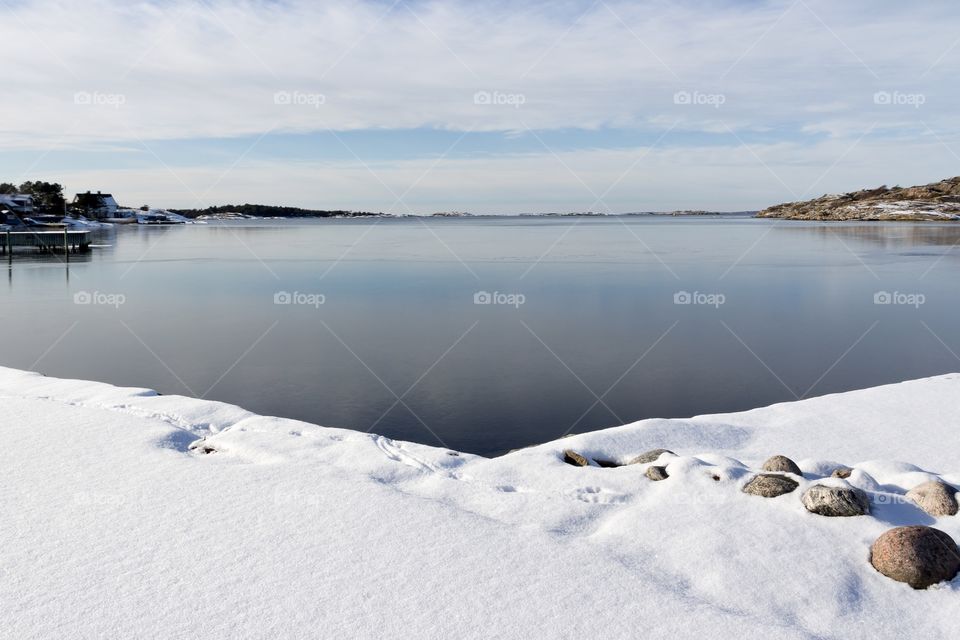 Frozen ocean, sky and cloud reflection in the ice, beautiful winter day with snow 