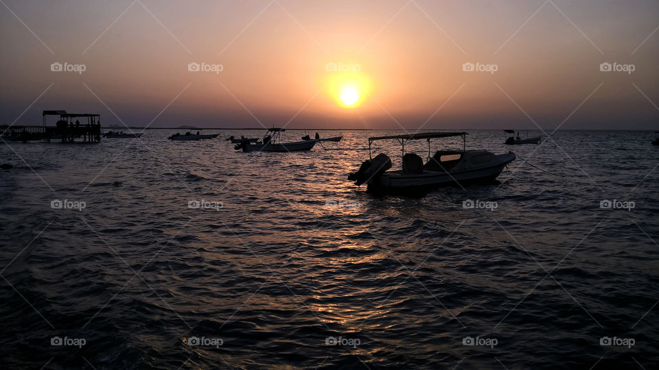 Local fishermen boats inside sea at sunset