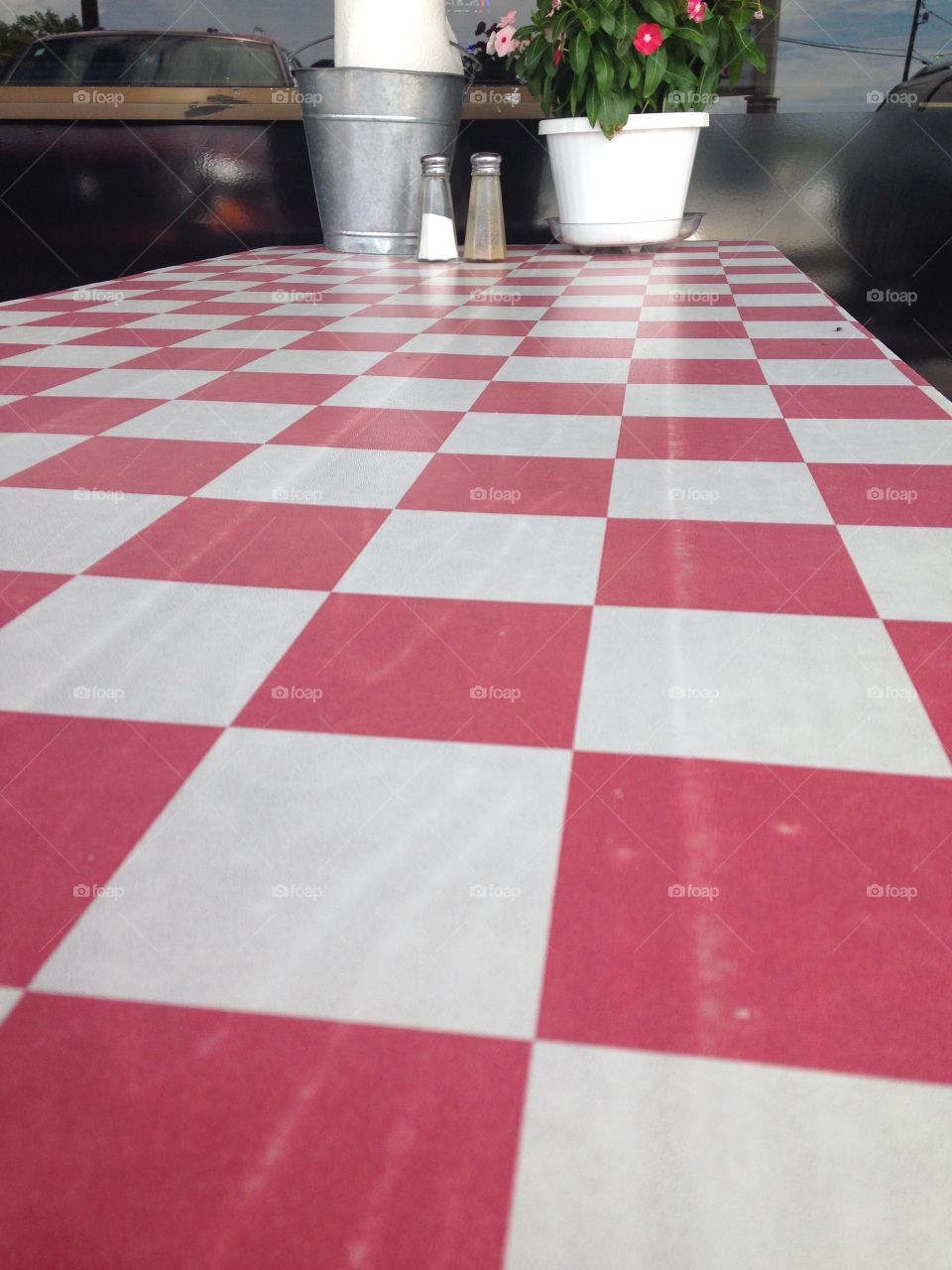 Summer picnic. Red checkered table with flowers, napkins, and salt/pepper shakers