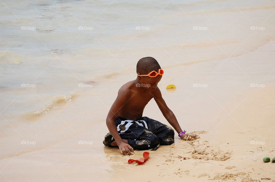 Boy playing in the sand on the beach