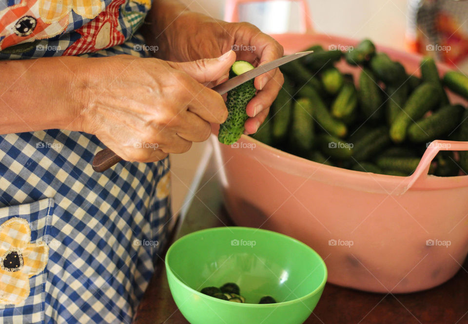 A woman cuts cucumbers
