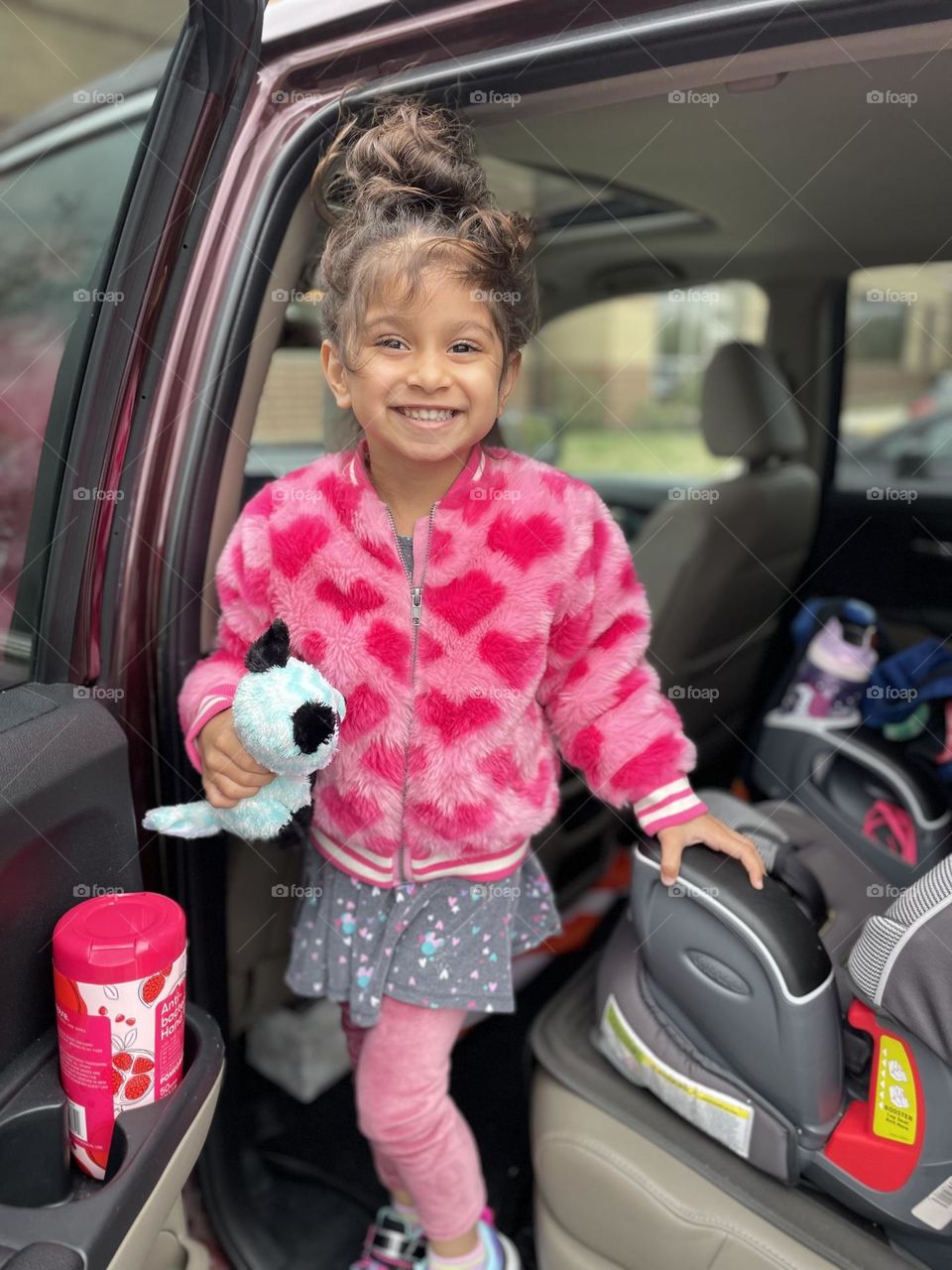 Child smiles while getting out of car, child excited about Fall time weather, smiling for Mommy