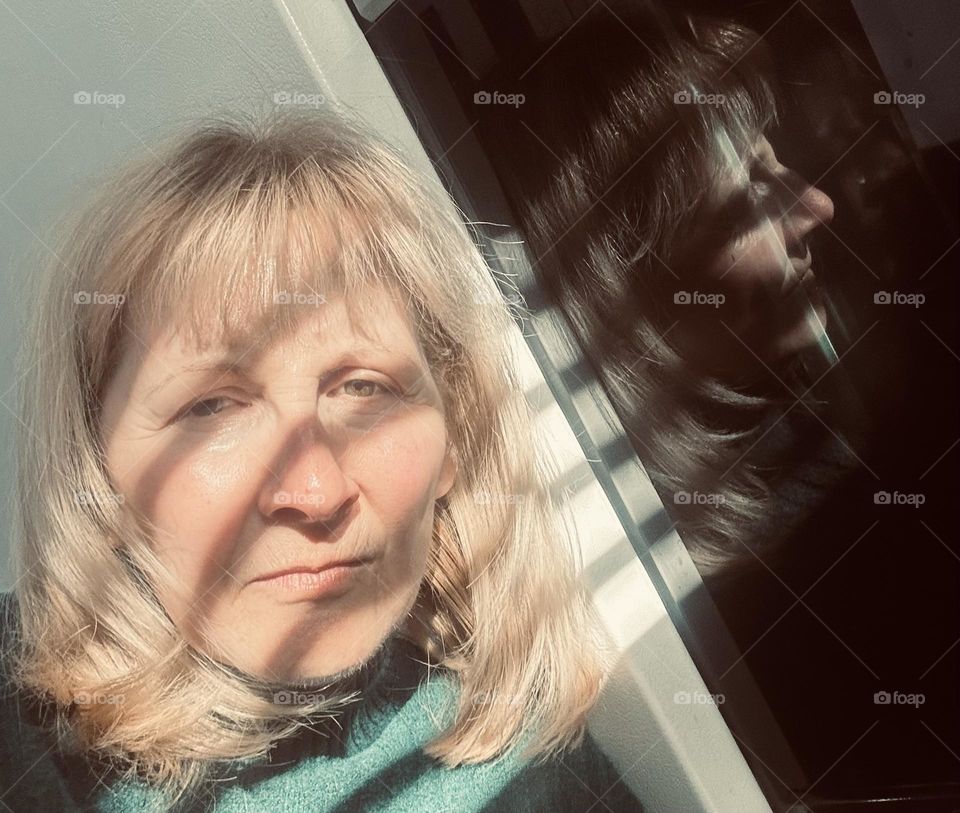 Woman with shadows on her face and reflection in oven door