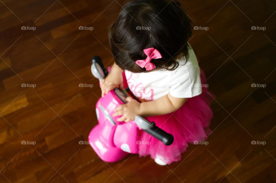 little girl taking a ride on the pink motorcycle