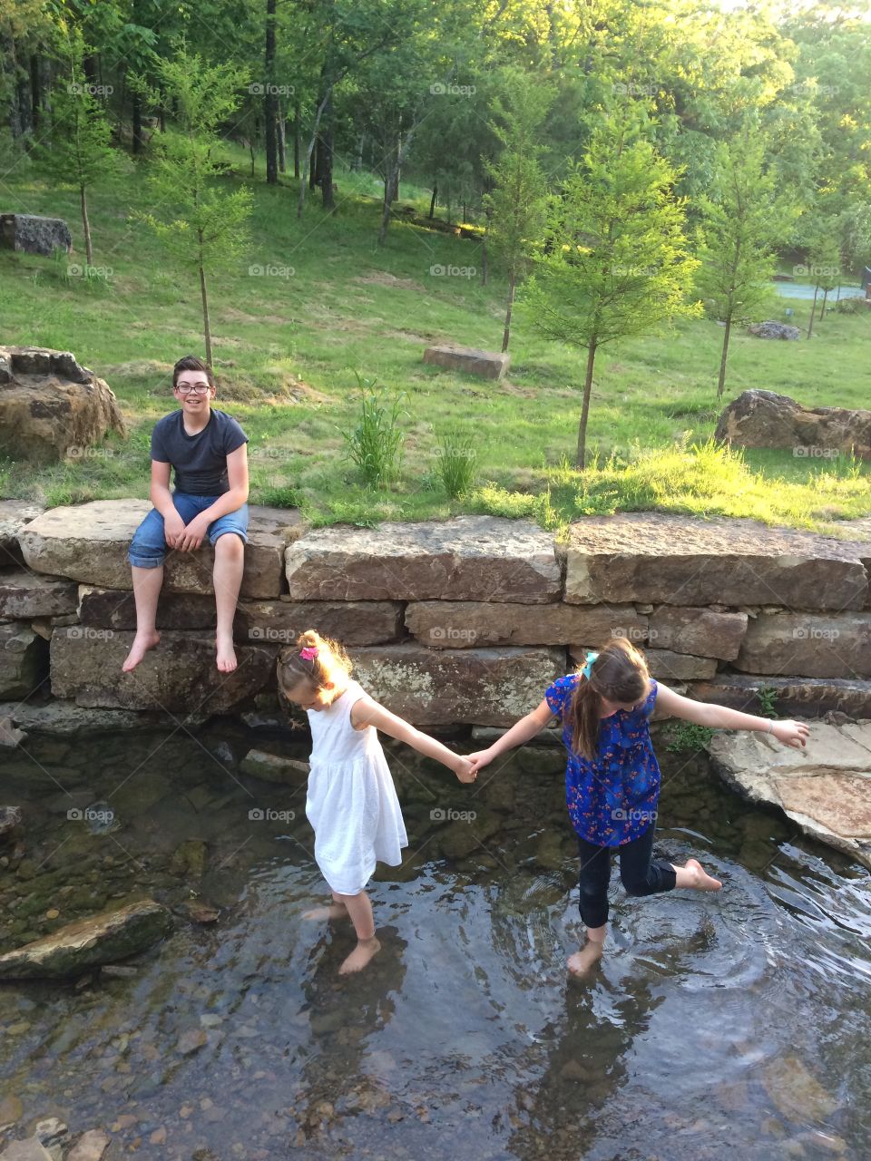 Siblings walking in water
