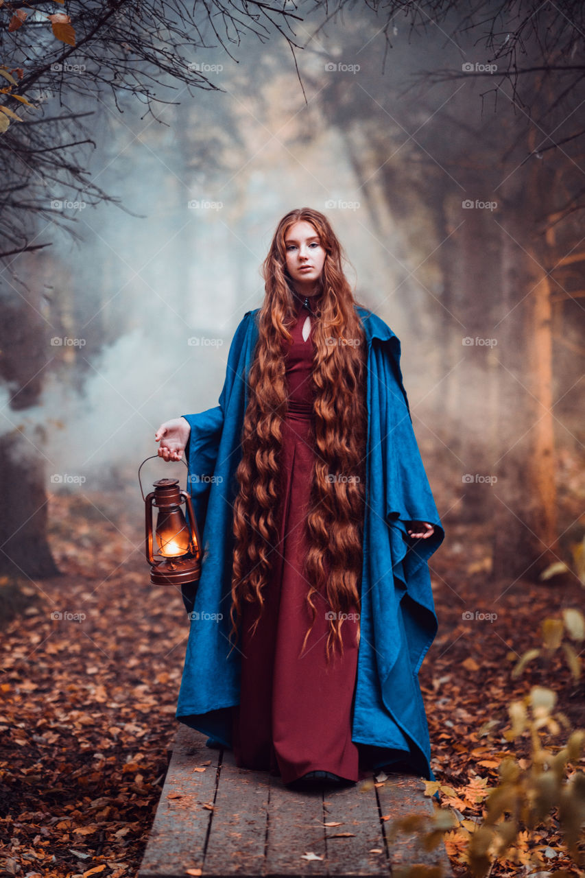 A beautiful girl with long red hair in a blue coat