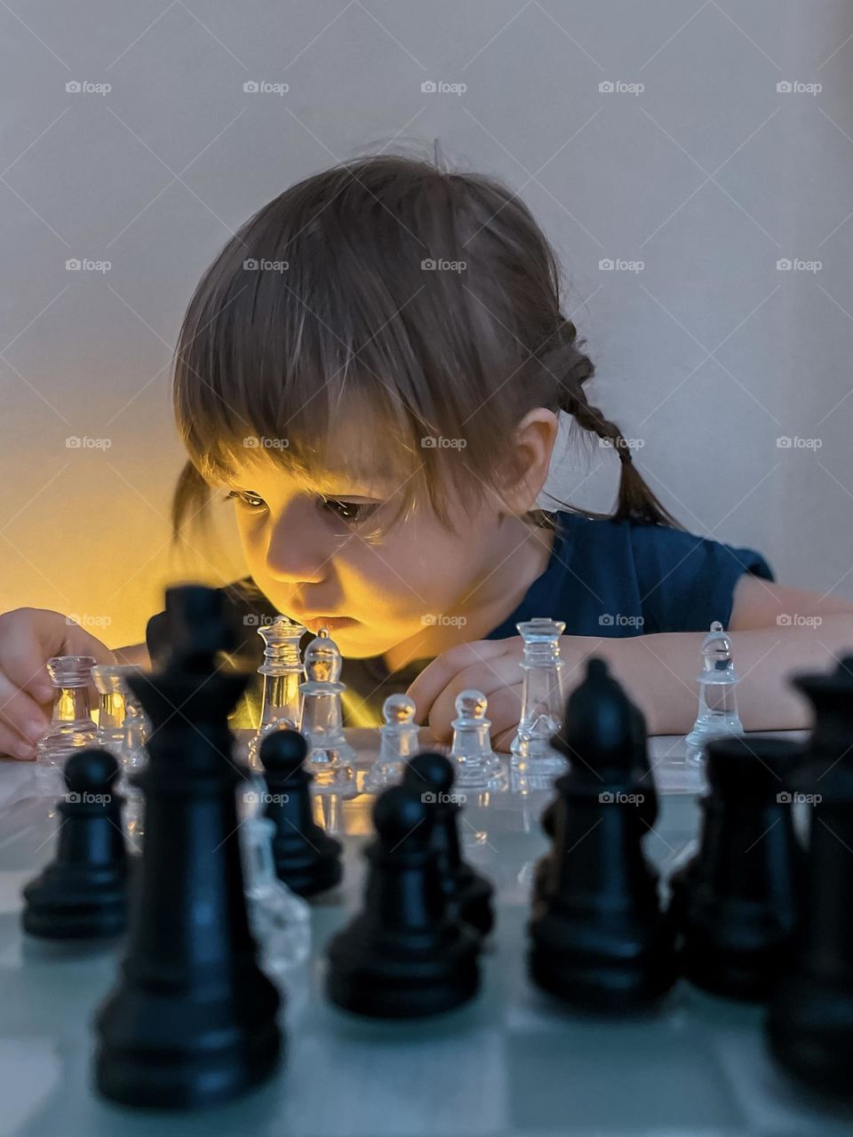 A little girl is playing chess