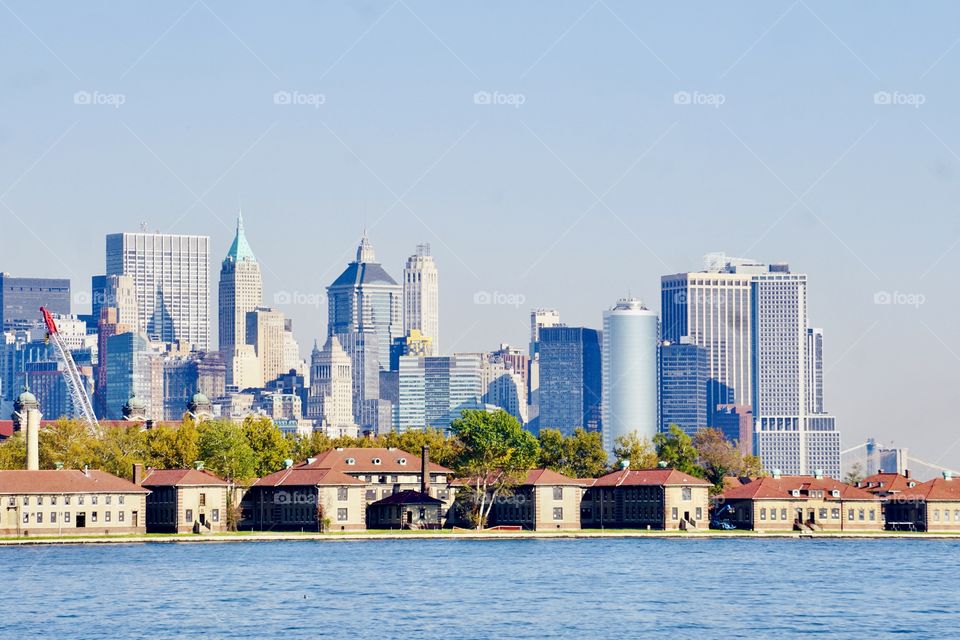 View from Liberty State Park- The buildings of historic Ellis Island looms in the foreground against the backdrop of the buildings of downtown Manhattan.