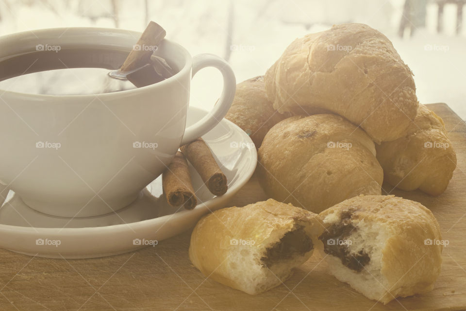Coffee with croissants for breakfast. Cinnamon sticks