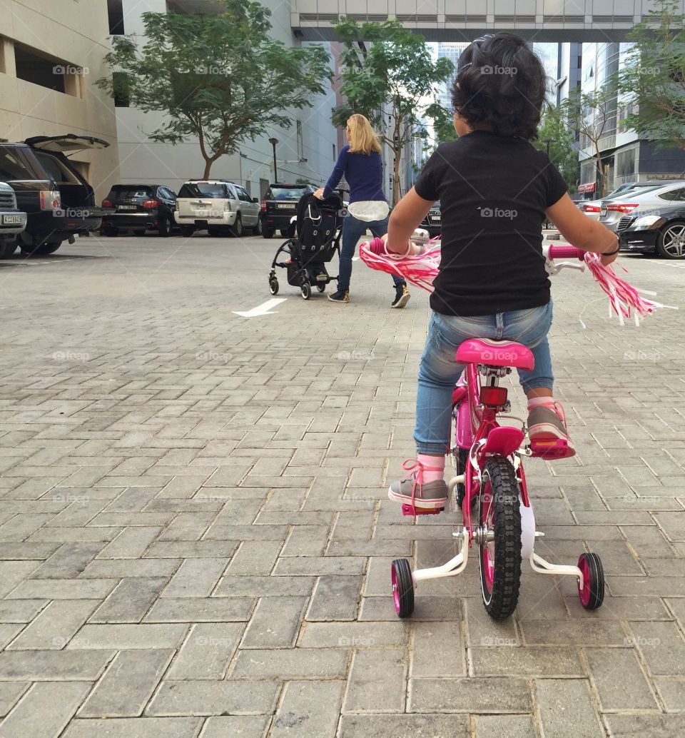 Toddler girl learning to ride a bicycle 