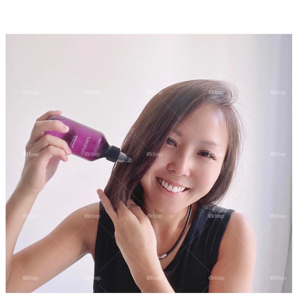 Asian woman with home salon hair treatment by Korea product 
