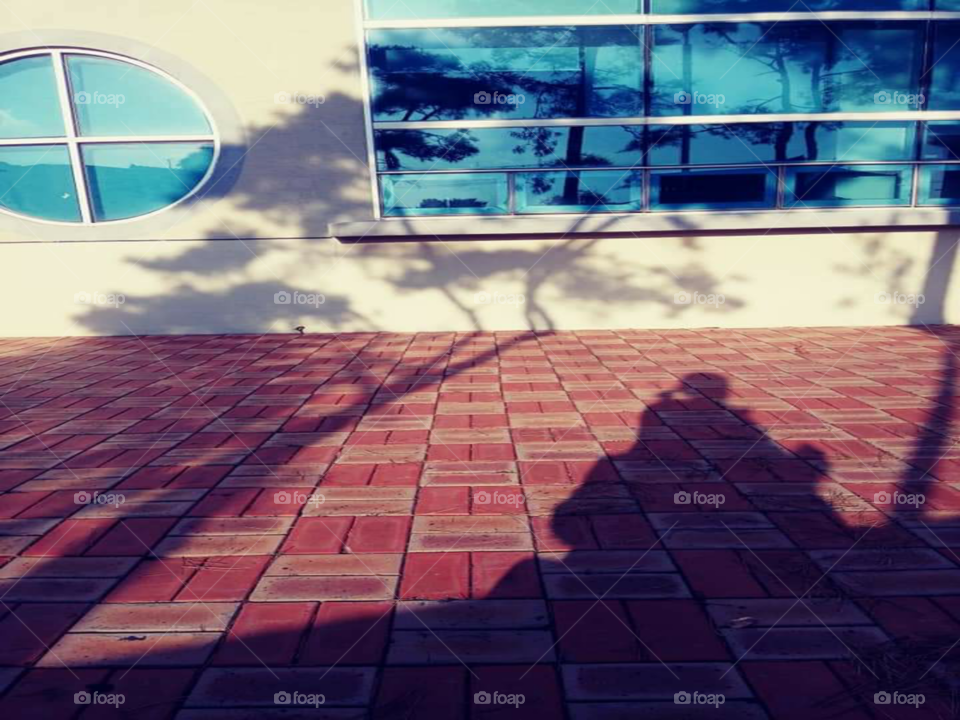 the shadow of a child who's  sitting at the lap of the mother.