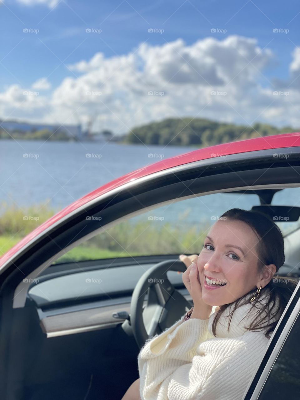 Young girl in a red Tesla car