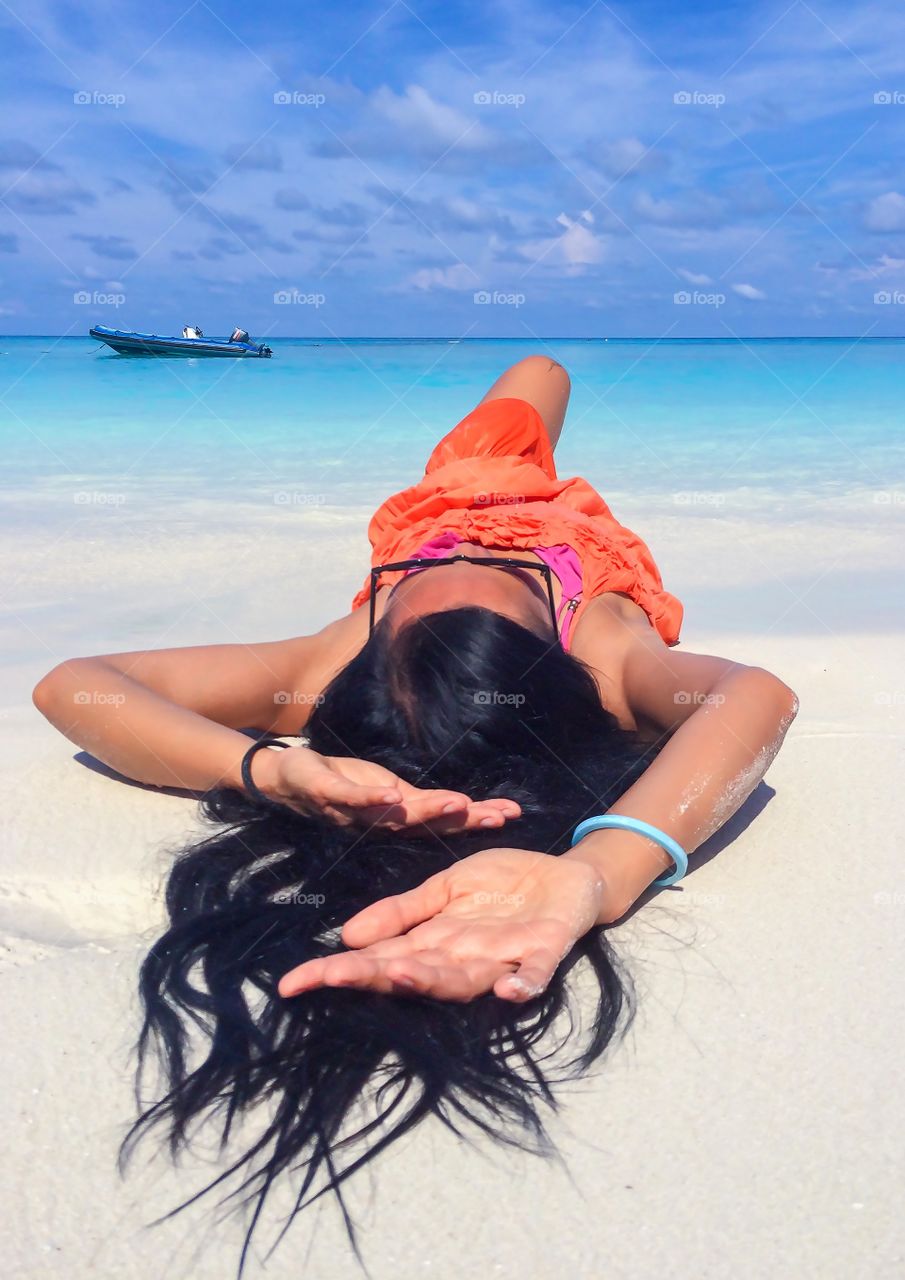 Young woman lying on sand at beach