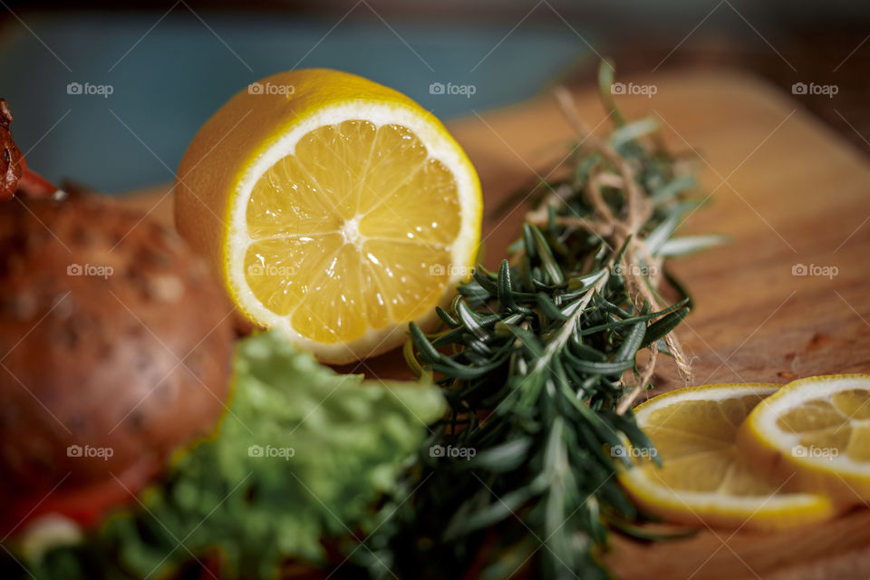 Lemon with rosemary on wooden board