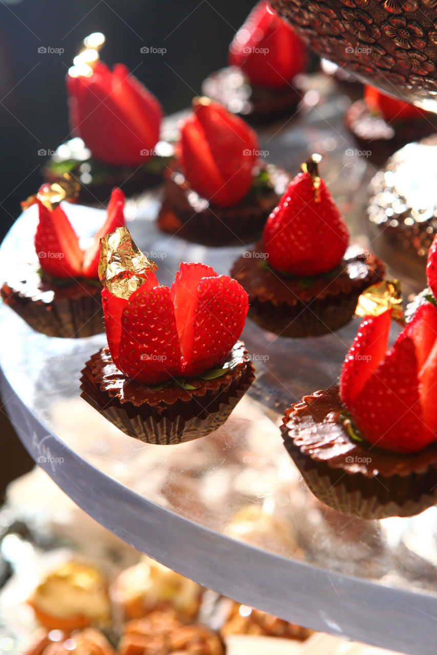 Chocolate fudge mini cakes with gold leaf crowned berries on top