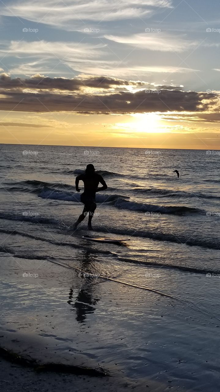 Skim boarding at sunset at Clearwater Beach