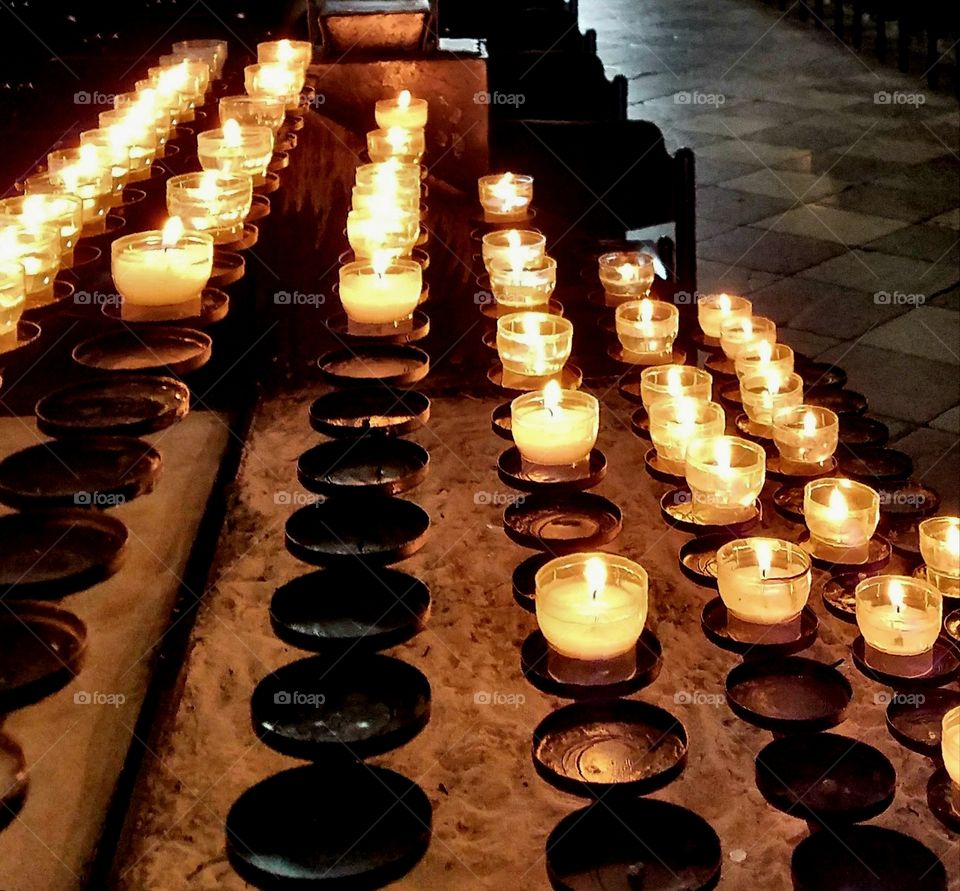 cathedral prayer candles, close-up, with slate walkway in background