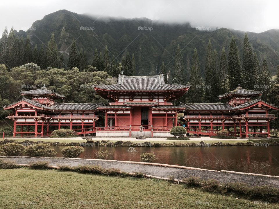 Buddhist Temple in the Mountains. An incredible Buddhist temple found in the mountains of Oahu, Hawaii. The mixture of colors and wonderful architecture are beautifully placed in front of a serene coy pond.