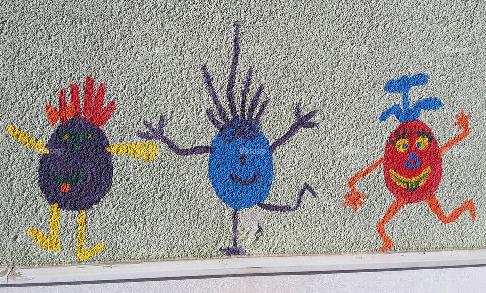 three funny little guys on a wall