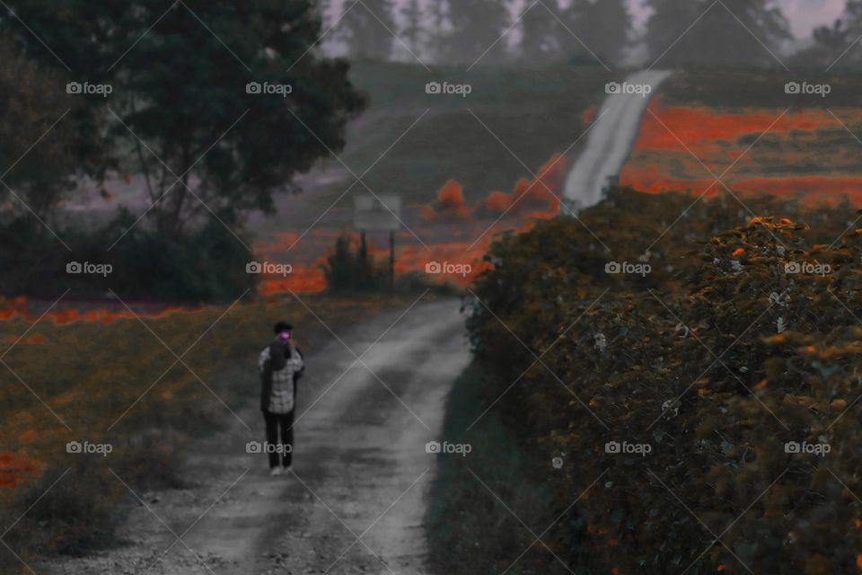 Waiting for sunrise in autumn. Two persons walking at the dirt road.
