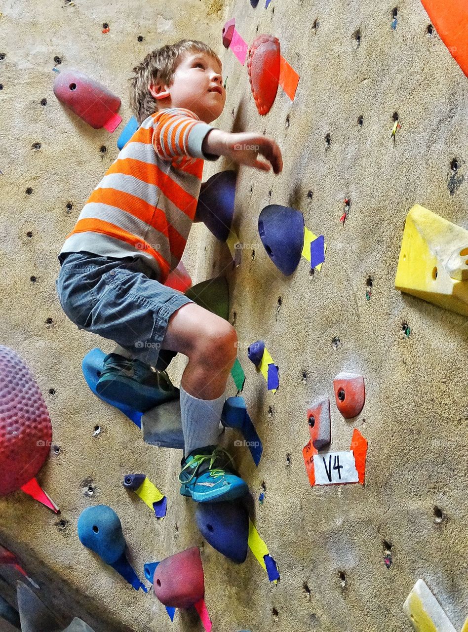 Young Rock Climber. Boy Practising Bouldering Skills
