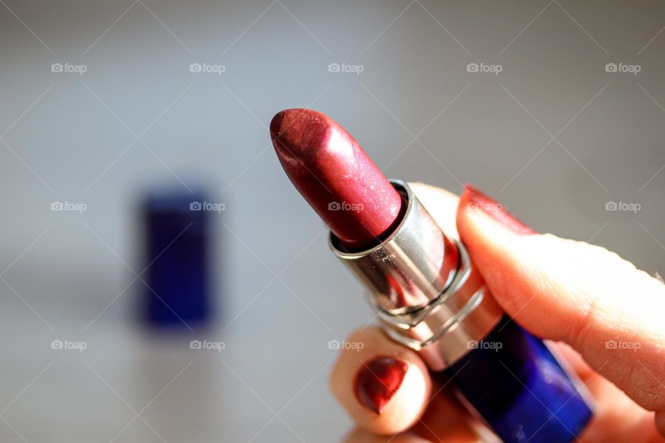 Woman is about to use magenta lipstick