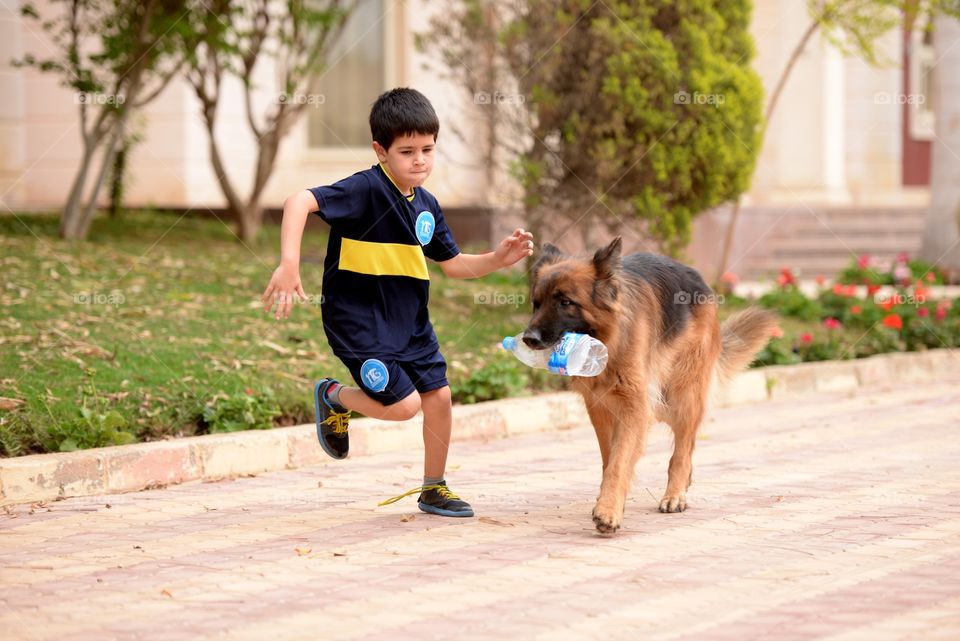 a boy running with his dog