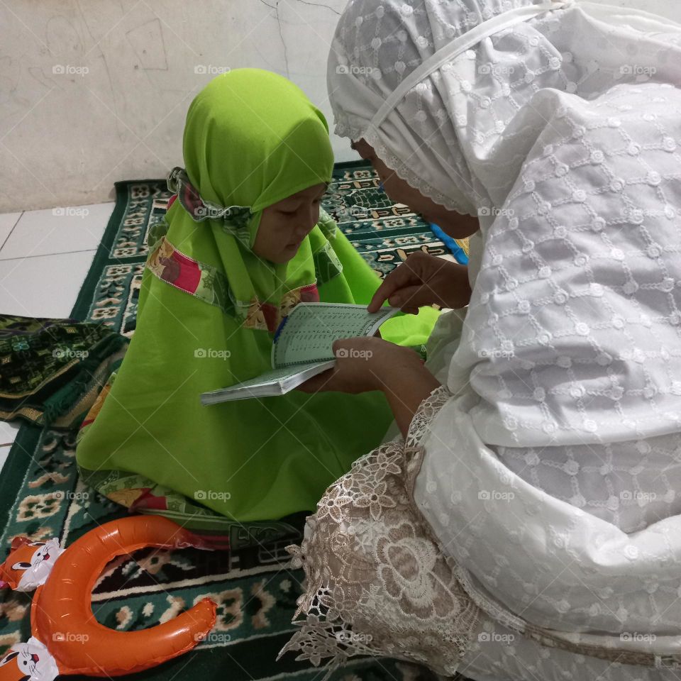 Little girl learning to read on the morning of ramadon