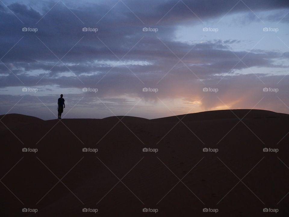 Man looking the sunset on a dune 