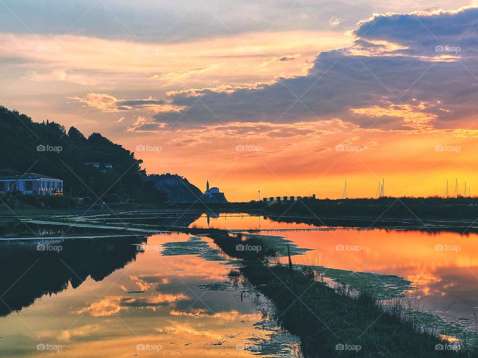 Scenic view of Adriatic sea, coast against orange sunset sky in Slovenia. Summer time. Vacation. Landscape
