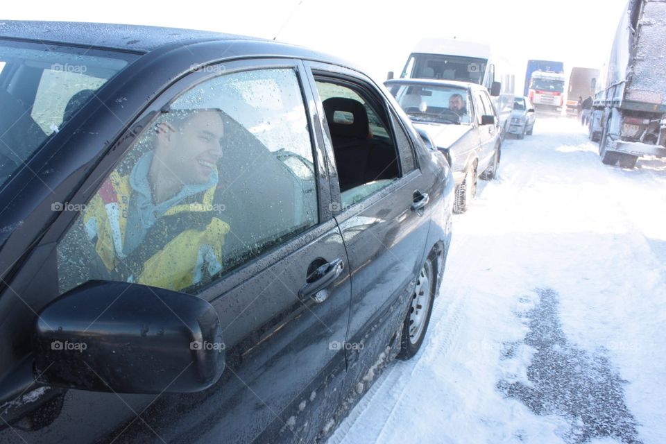 Car traffic stuck in the field full on strong snow storm. 