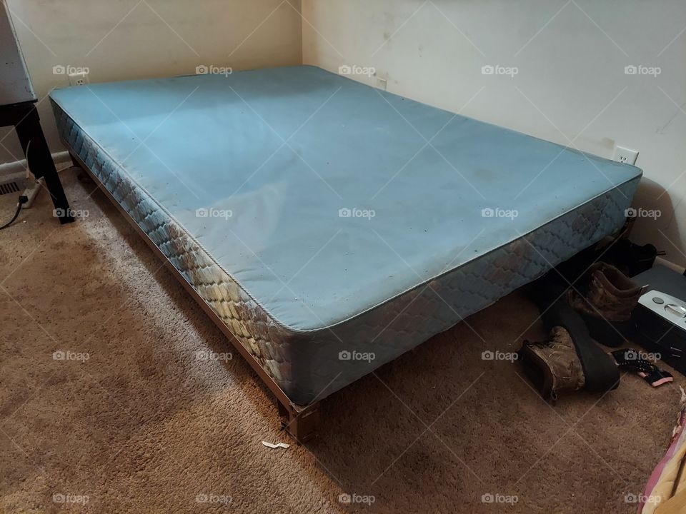Empty Box Spring Mattress on Bed Frame in Bare Room