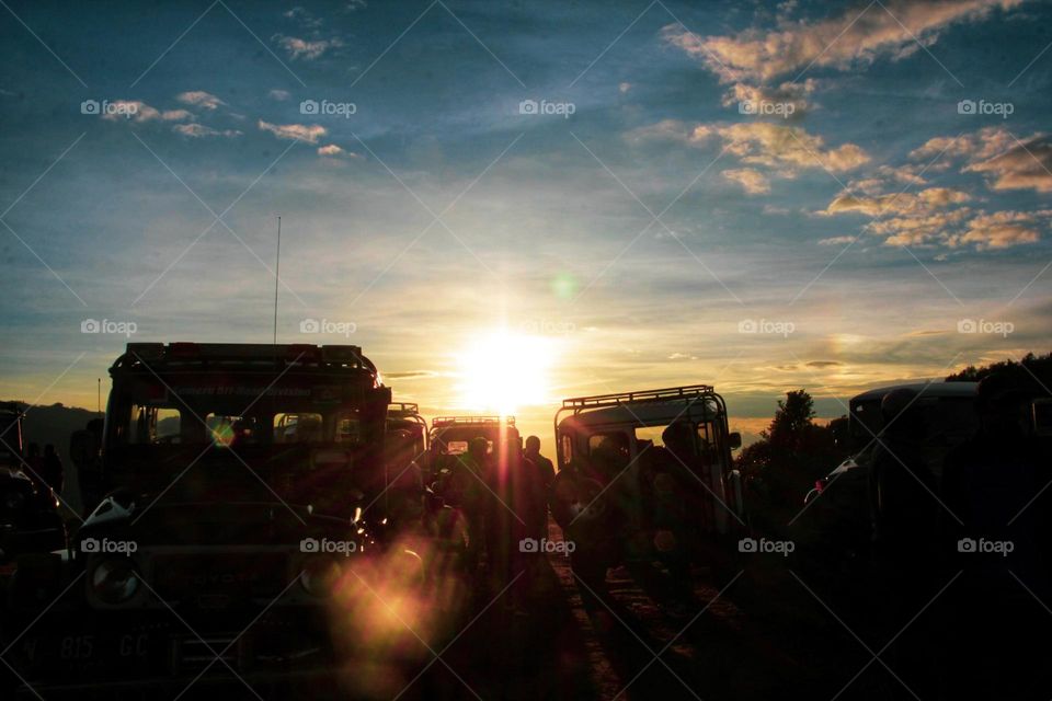 Sunrise that illuminates the car parking area on a hill in the Bromo mountains, East Java.