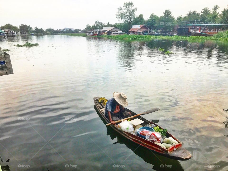 Man traveling in boat with fruits and vegetables