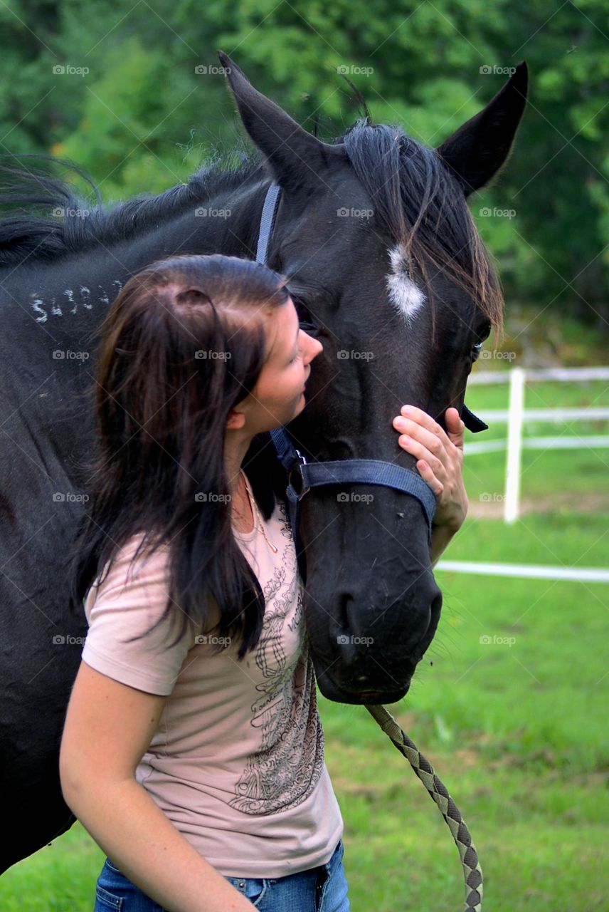 Young woman taking care of her horse