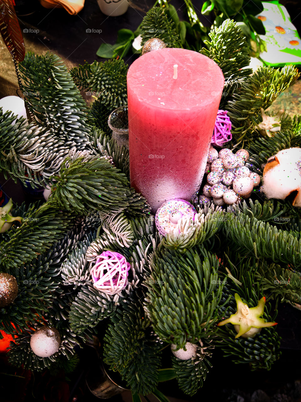 Decorative wreath of fir branches, glowing garlands and a candle