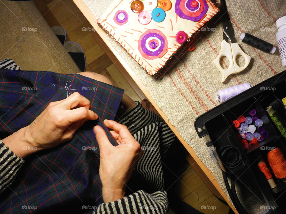 the girl sews a skirt in the autumn evening