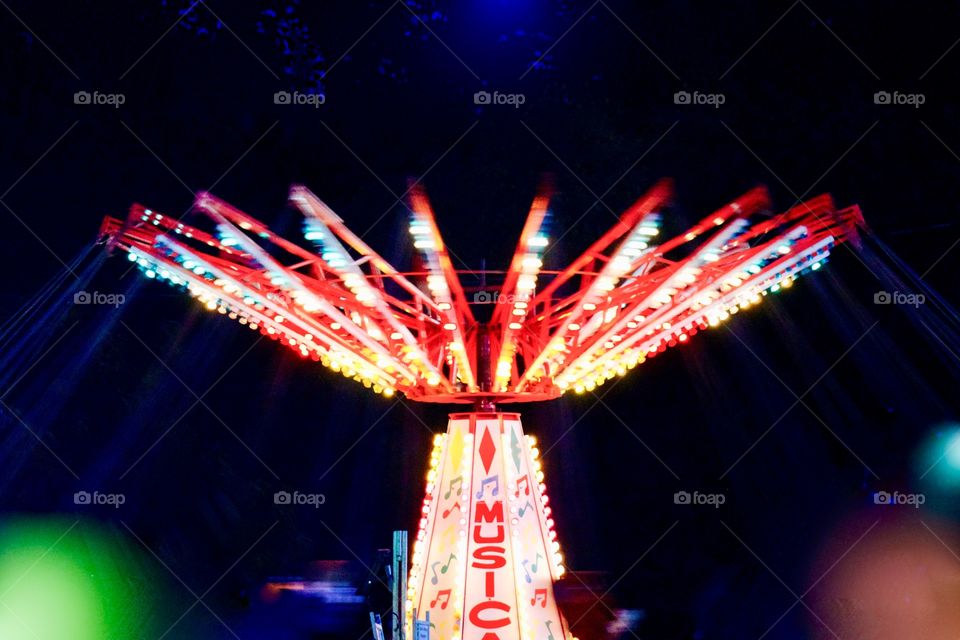 Multicolored lights of a ride at a fairground at night
