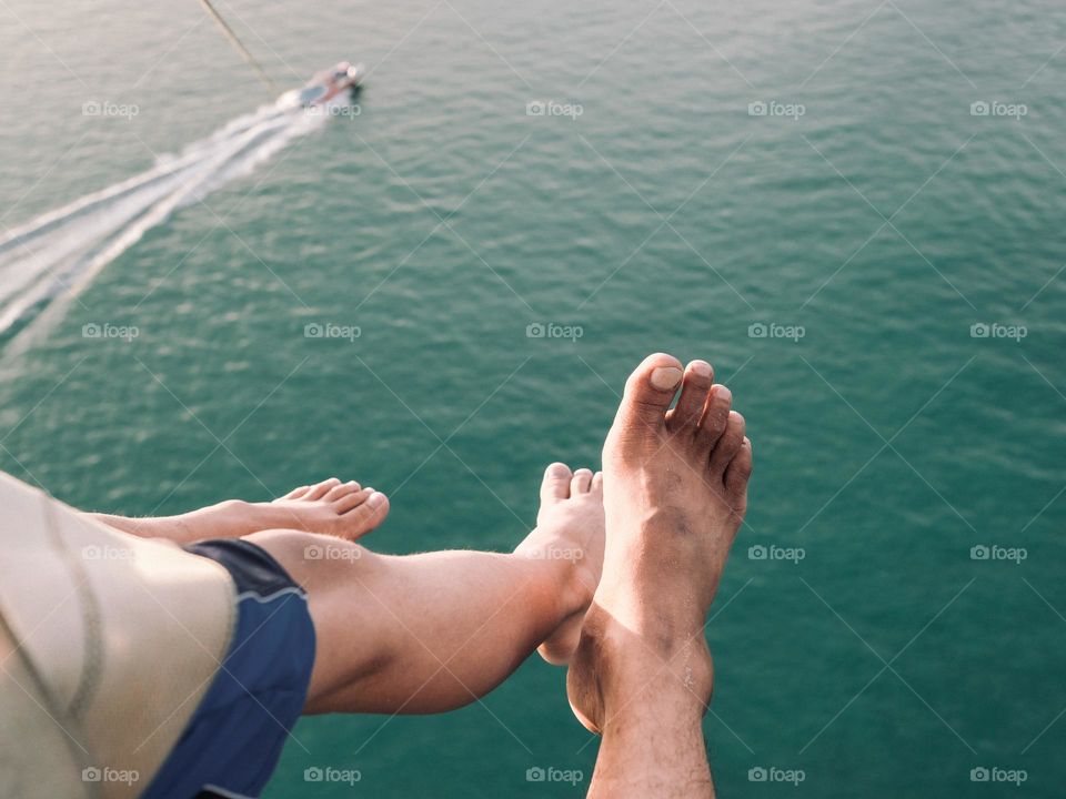 Father and son wind surfing above the ocean in Langkawi, Malaysia