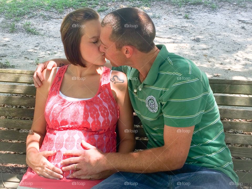 Couple sitting on bench kissing