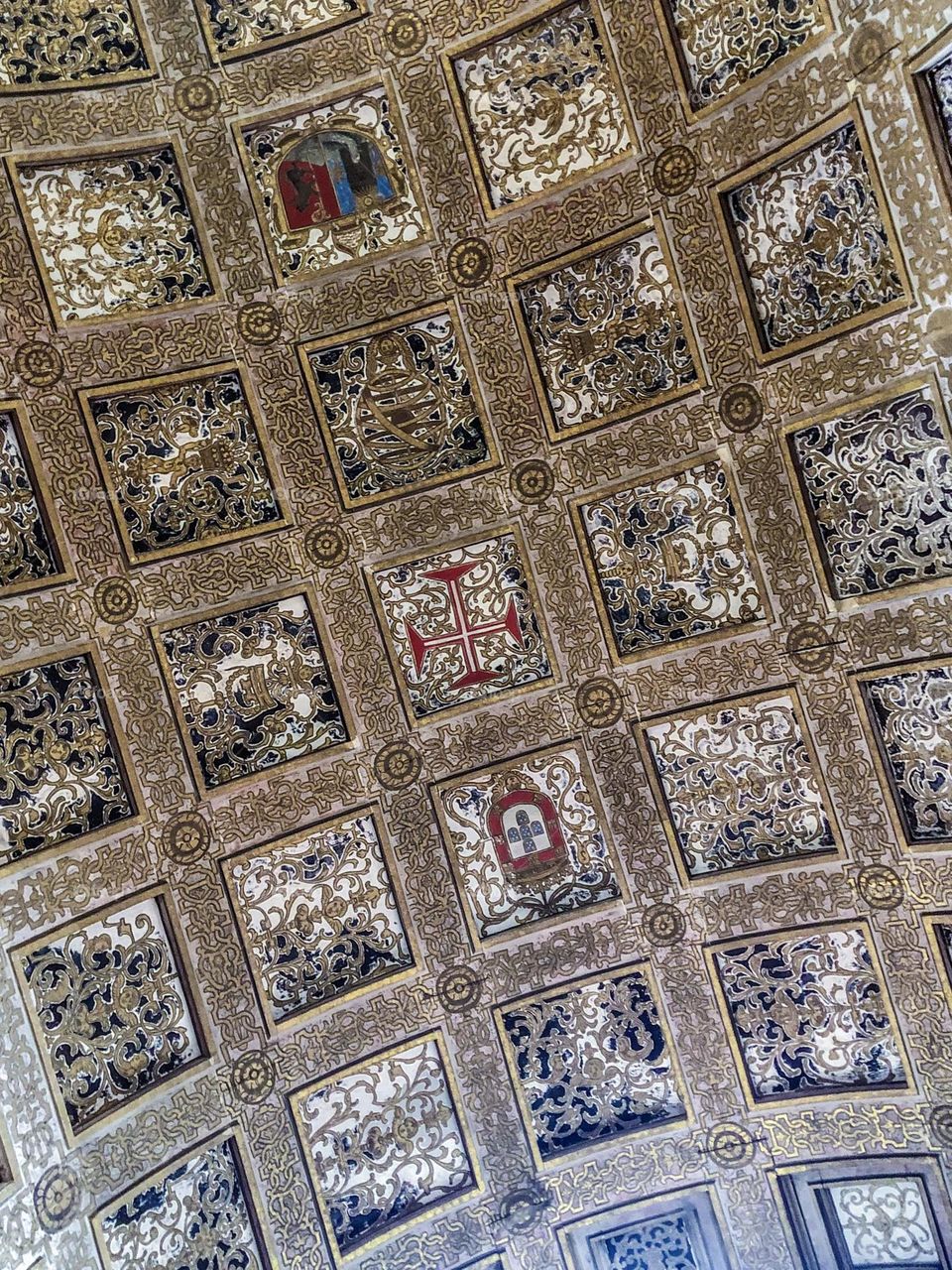 Decorative squares including the Templar cross adorn this curved ceiling at Convento de Cristo in Tomar, Portugal 