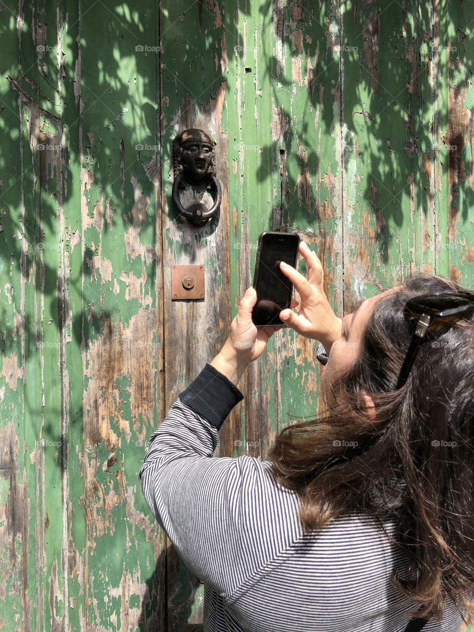 a green door and someone taking pictures on an iron fence
