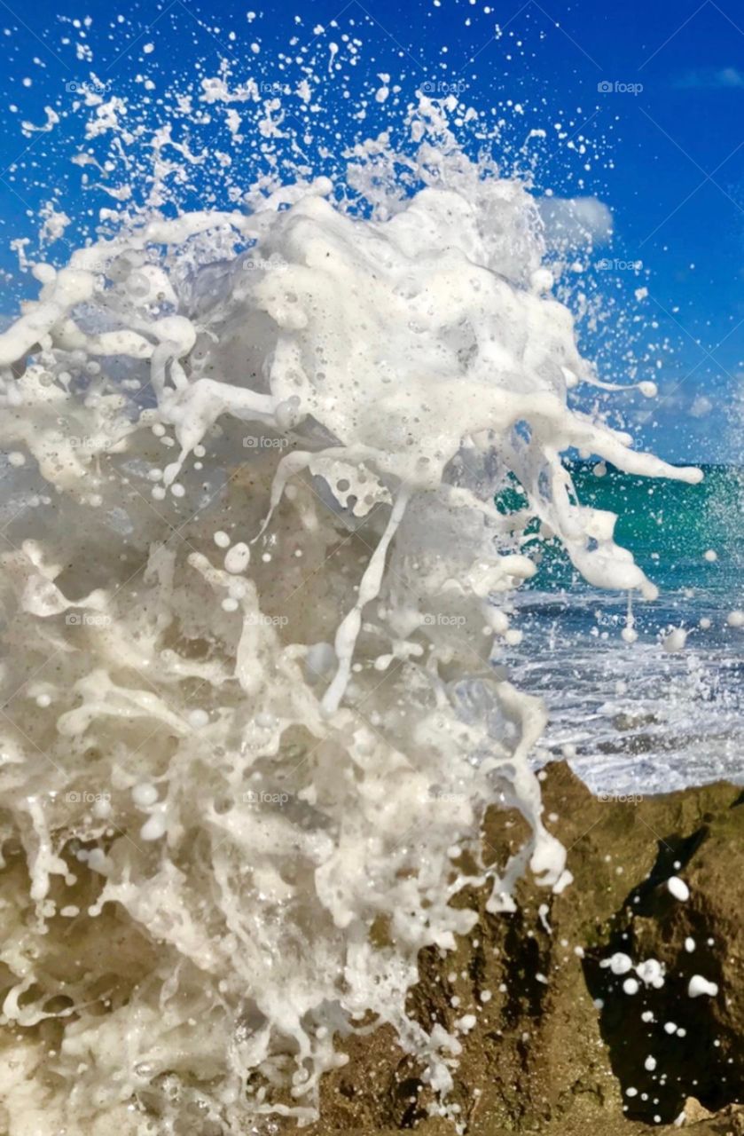 A close up of a wave splashing with details of sea foam