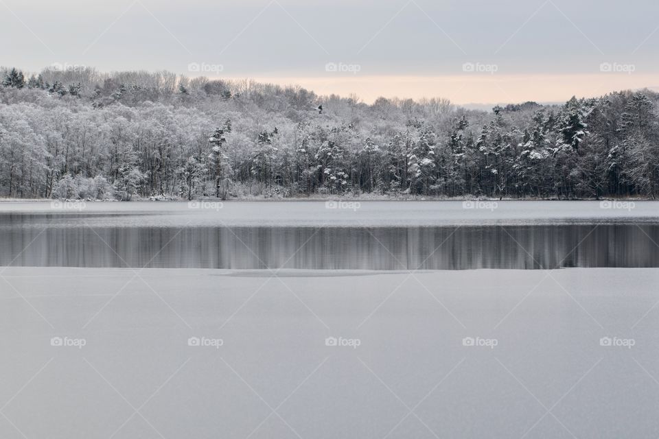 Forest reflection in winter landscape - vinterlandskap sjö is snö skog