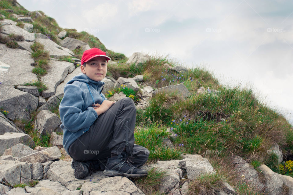 Boy resting on mountain trail