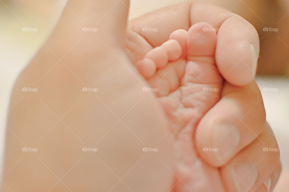 Cropped hand on mother holding baby foot